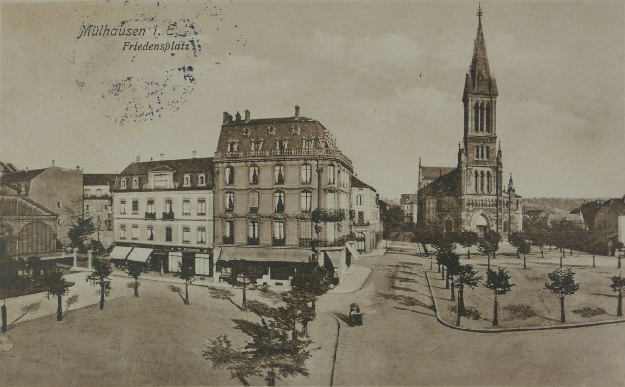 La place de la Paix. A l’arrière plan, l’Eglise Saint-Etienne. Sur la droite, les halles du marché - vers 1915